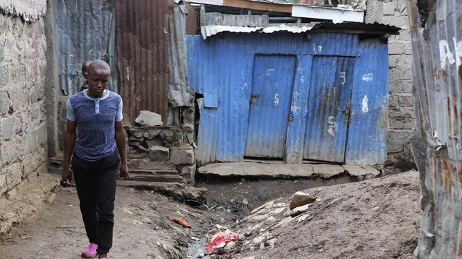 Una calle de un slum, con aguas residuales cerca de las viviendas.